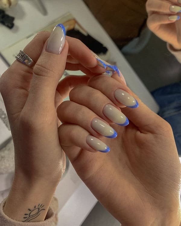 Milky nude almond nails with fine electric blue outline nail art